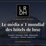 Logo de La Revue des Hôtels (LRDH) sur la façade d'un palace parisien au bord de la Seine, avec le titre « Le média n°1 mondial des hôtels de luxe »